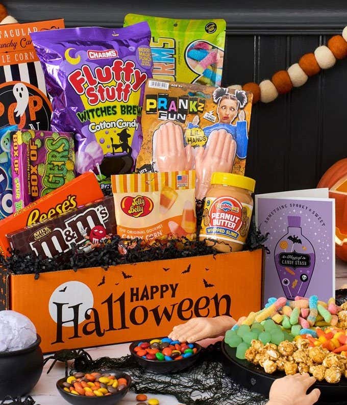 Gift Box with spider web cotton candy, caramel popcorn, haribo goldbears, halloween junior mints, plain m&m's, sugar babies, ghost dots, kettle corn, gummy worms, black & white cookies, and candy corn