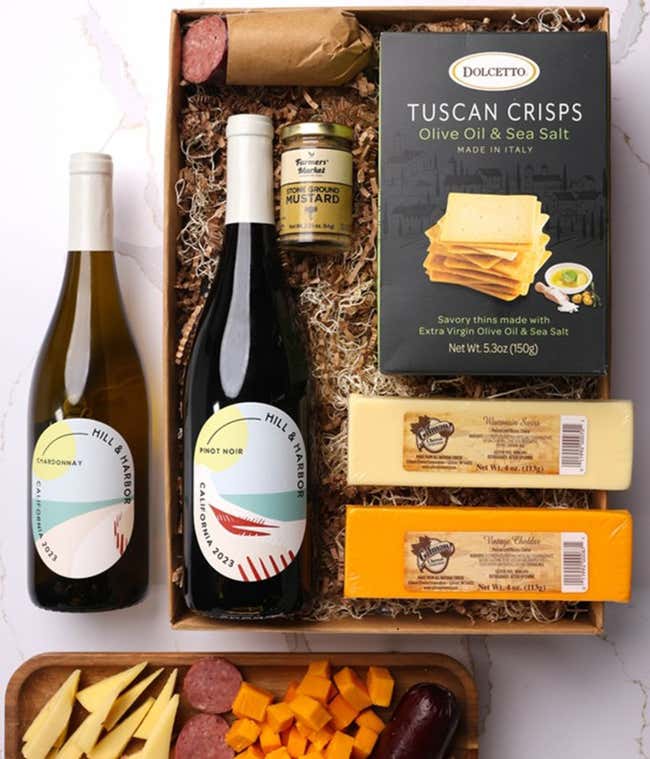 A gift box with two bottles of California wine - Pinot Noir and Chardonnay, two types of cheese, crackers, stone-ground mustard, and a summer sausage.