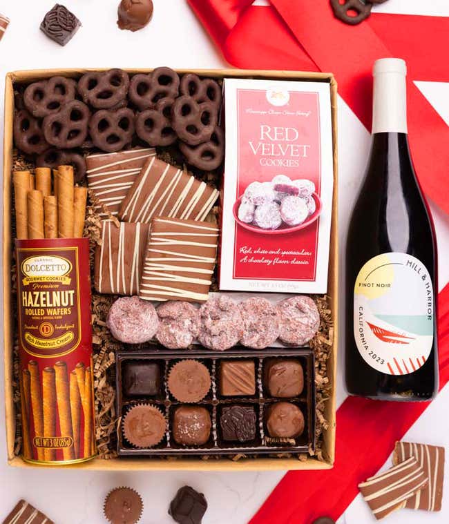 A gift box with chocolate pretzels, chocolate graham crackers, red velvet cookies, hazelnut wafer rolls, an 8 piece box of chocolates and a Season's Greeting message card.