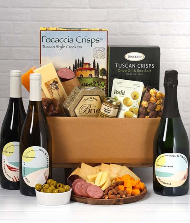 A wine and cheese gift set featuring bottles of Hill &amp; Harbor Sparkling wine, Chardonnay, and Pinot Noir. Includes a variety of cheeses, crackers, olives, smoked almonds, summer sausage, and condiments.