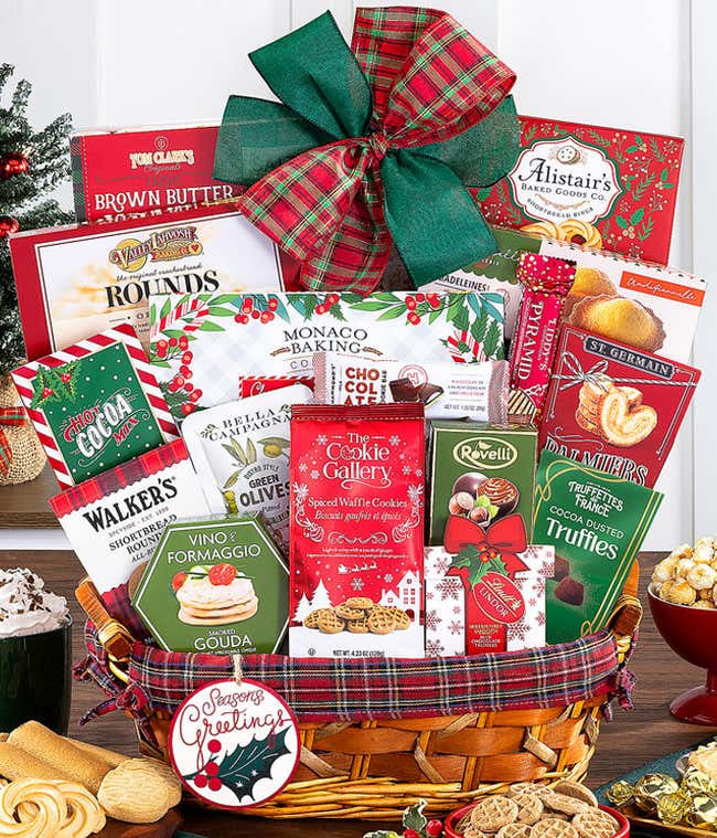 Festive gift basket filled with assorted gourmet treats, including chocolates, cookies, cheese, and crackers, decorated with a red and plaid ribbon and a Seasons Greetings ornament.