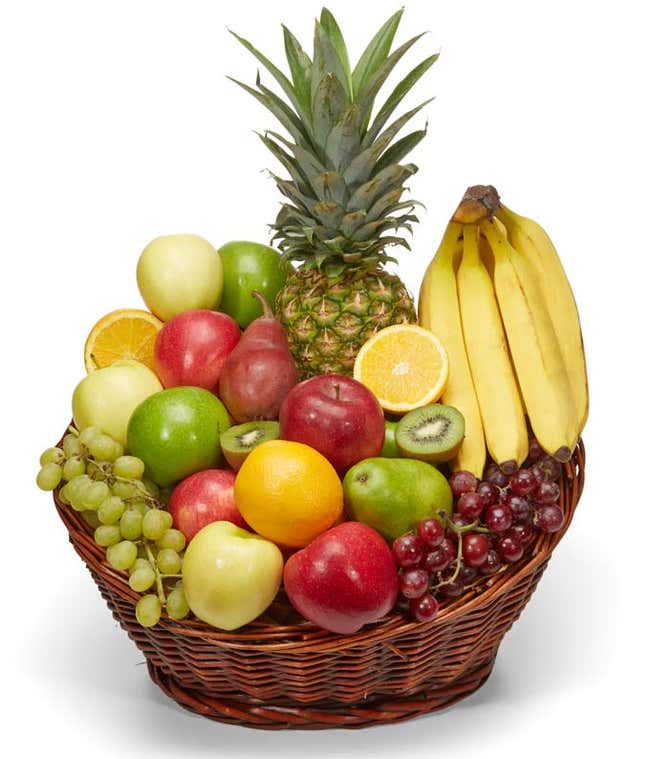 Wicker basket filled with a variety of fresh fruit including a pineapple, bananas, red and green apples, pears, oranges, kiwi, grapes, and a sliced orange.