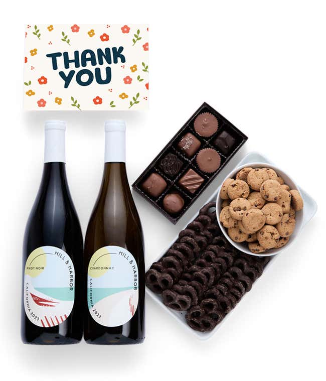 A gift box with chocolate pretzels, chocolate graham crackers, red velvet cookies, hazelnut wafer rolls, an 8 piece box of chocolates, 2 bottles of wine and a Thank You message card.