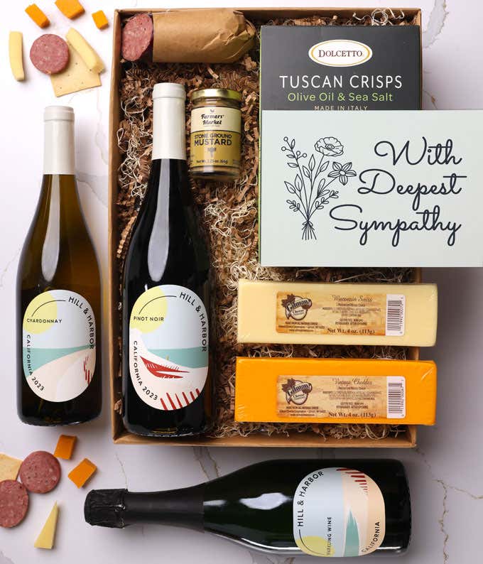 A gift box with three bottles of California wine (red, white, and sparkling), two types of cheese, crackers, stone-ground mustard, a summer sausage, and a With Sympathy message card.
